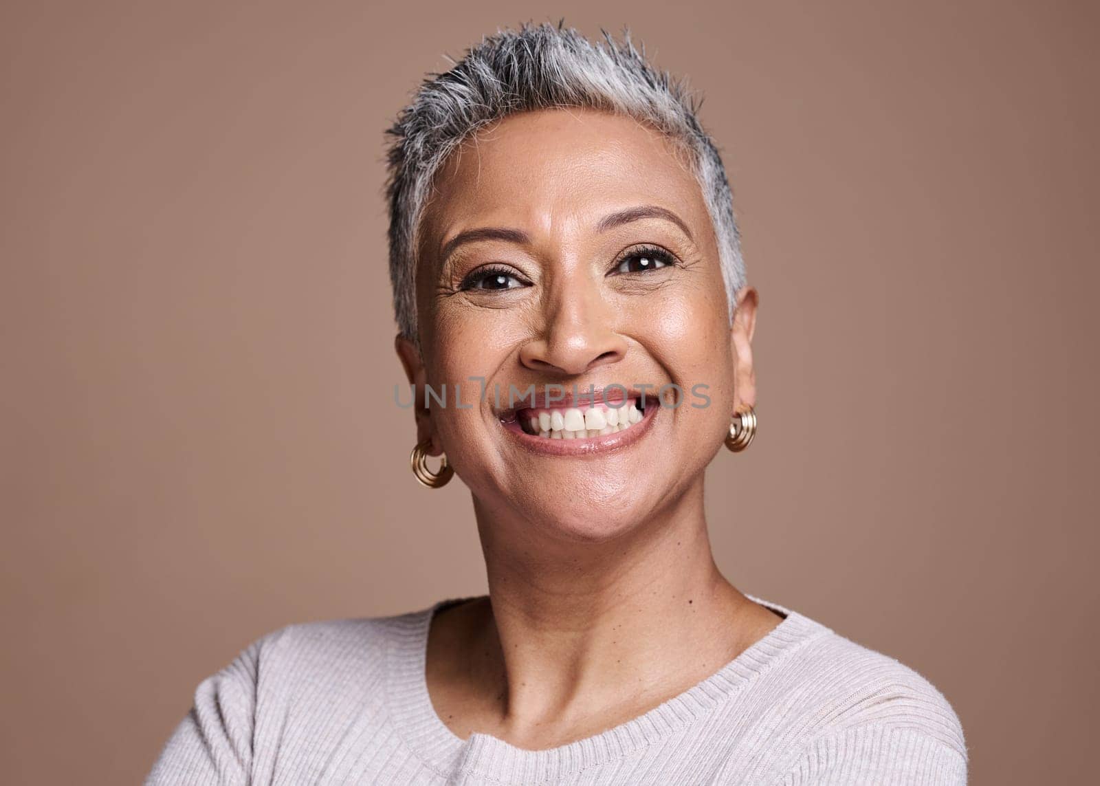 Black woman, beauty and smile in studio for senior skincare, cosmetics or fashion on brown background for health, wellness and motivation. Face portrait of mature model with perfect teeth and skin by YuriArcurs