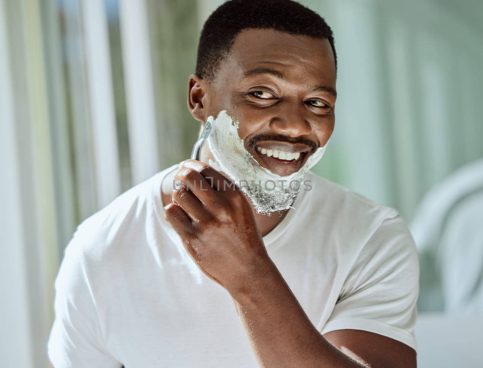 Cream, razor and shaving black man in the bathroom for skincare, beard grooming routine and facial care. Smile, treatment and African person start to shave face for hair removal with foam in morning by YuriArcurs