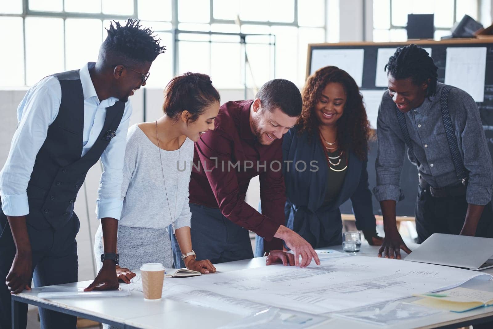 This is exactly what the client asked for. a team of professionals working on blueprints in an office