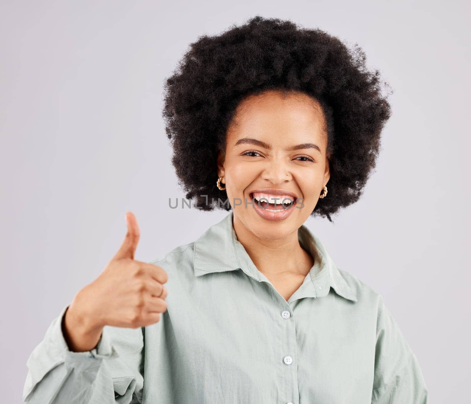 Portrait, thumbs up and black woman laughing in studio isolated on a white background. Success, happiness and person with hand gesture or emoji for winning, approval or agreement, like or thank you. by YuriArcurs