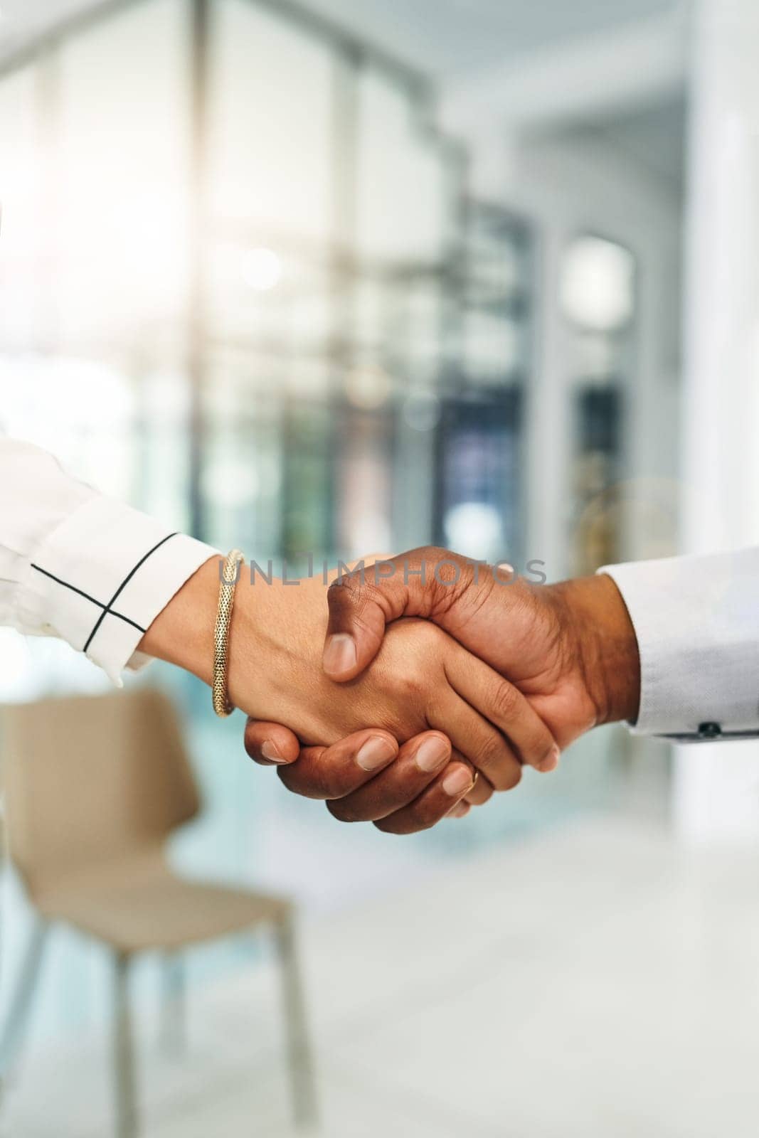 Heres to building a better business together. Closeup shot of two businesspeople shaking hands in an office. by YuriArcurs