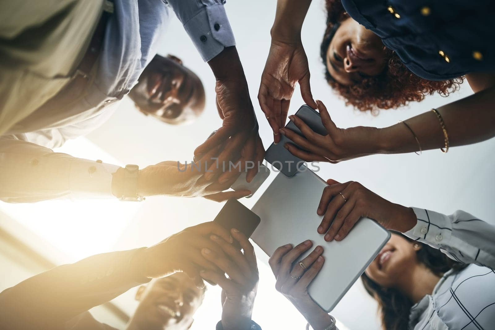 They never stray far from their connections. Closeup shot of a group of businesspeople using digital devices in synchronicity in an office