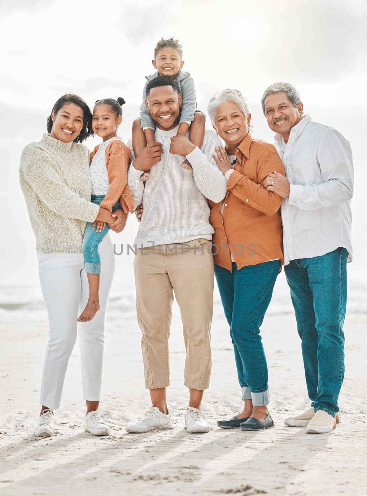 Happy family, travel portrait and beach with grandparents, parent love and kids together by sea. Outdoor, vacation and children with grandmother and father by ocean on holiday in group with a smile.