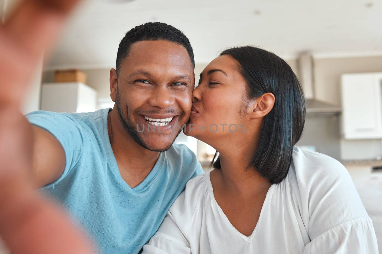 Young couple, kitchen and selfie with kiss, happiness or love with smile in post, social media app and home together. Man, woman and happy with photography, profile picture and internet blog in house.