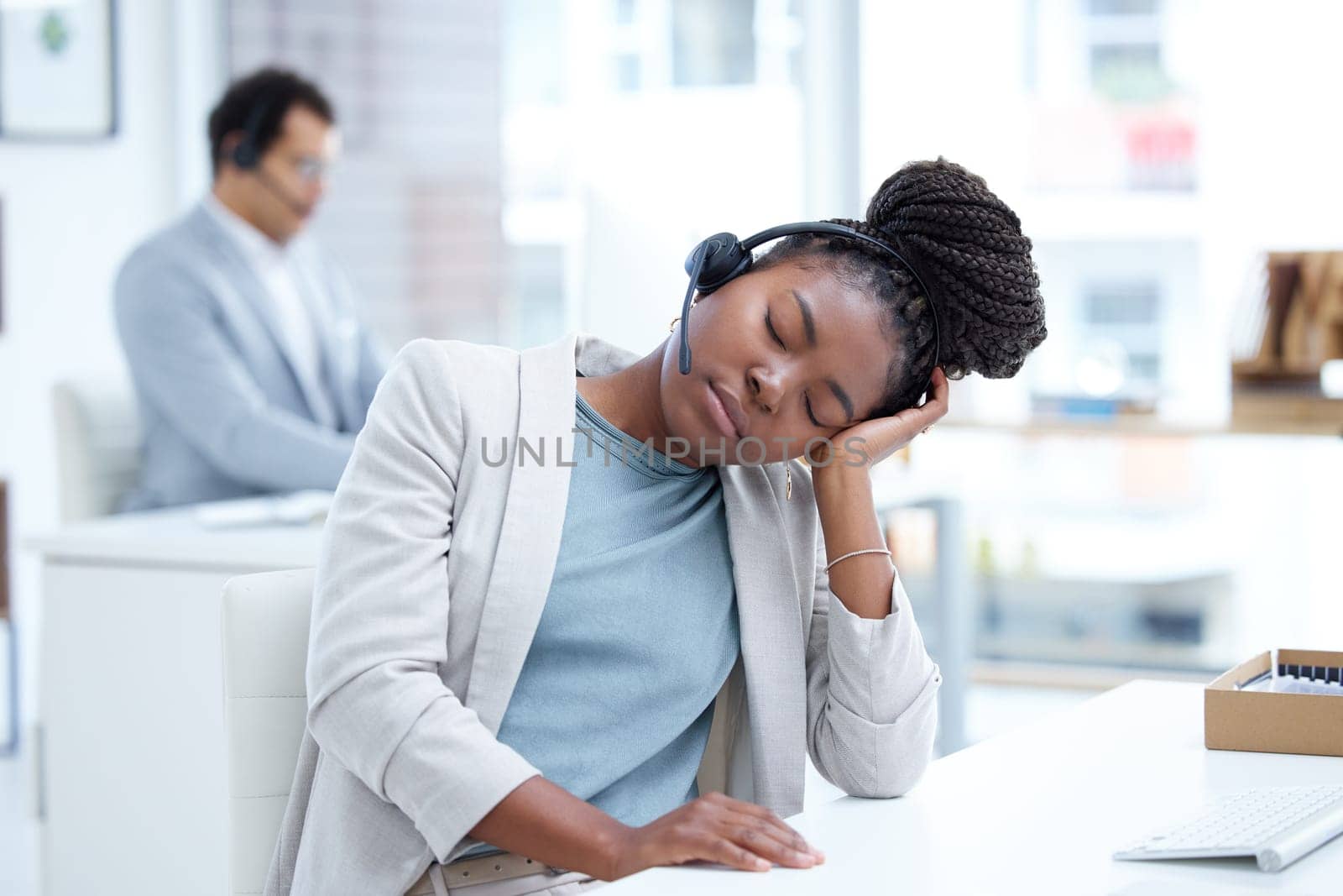 Call center, tired and woman sleeping with headset for telemarketing, sales or customer service. Black female consultant or agent at crm, tech support or help desk with stress, burnout or fatigue.