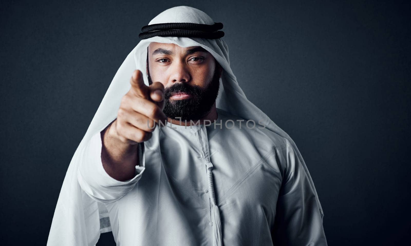 You are in charge of the success of your business. Studio shot of a young man dressed in Islamic traditional clothing posing against a dark background
