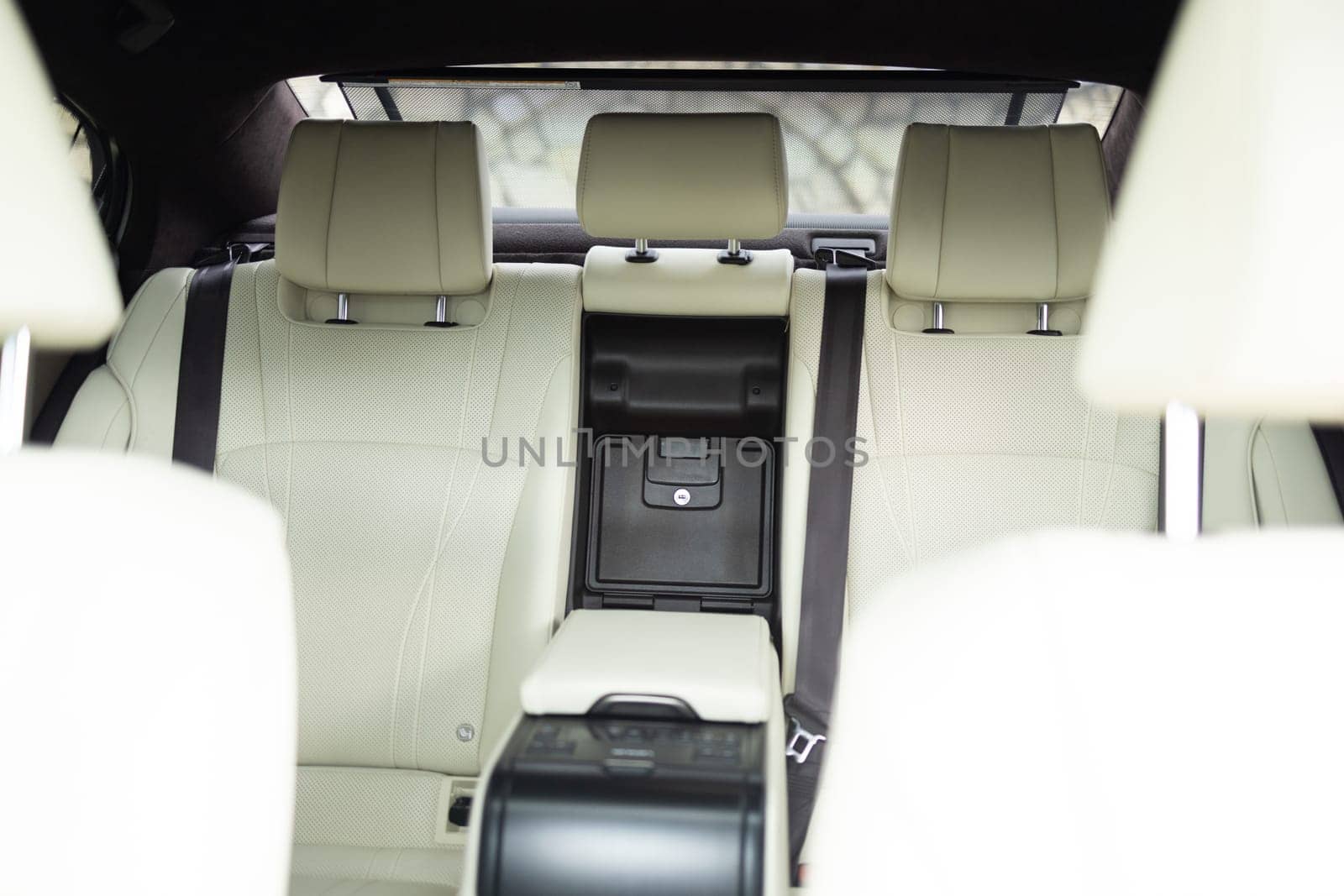 New car inside. Car cleaning theme. Luxury car rear leather seats row. Interior of new modern clean expensive car. Passenger seats with leather. Closeup details.