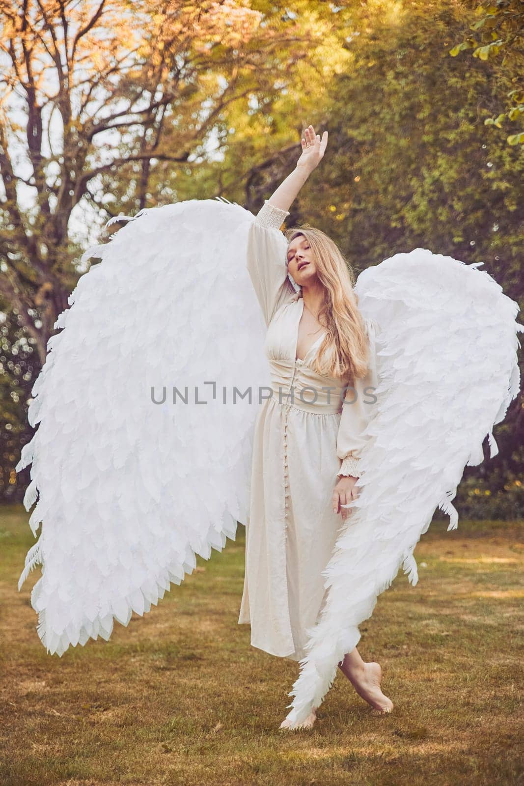 Olstrup, Denmark, June, 2023: girl dressed as an angel in the garden.