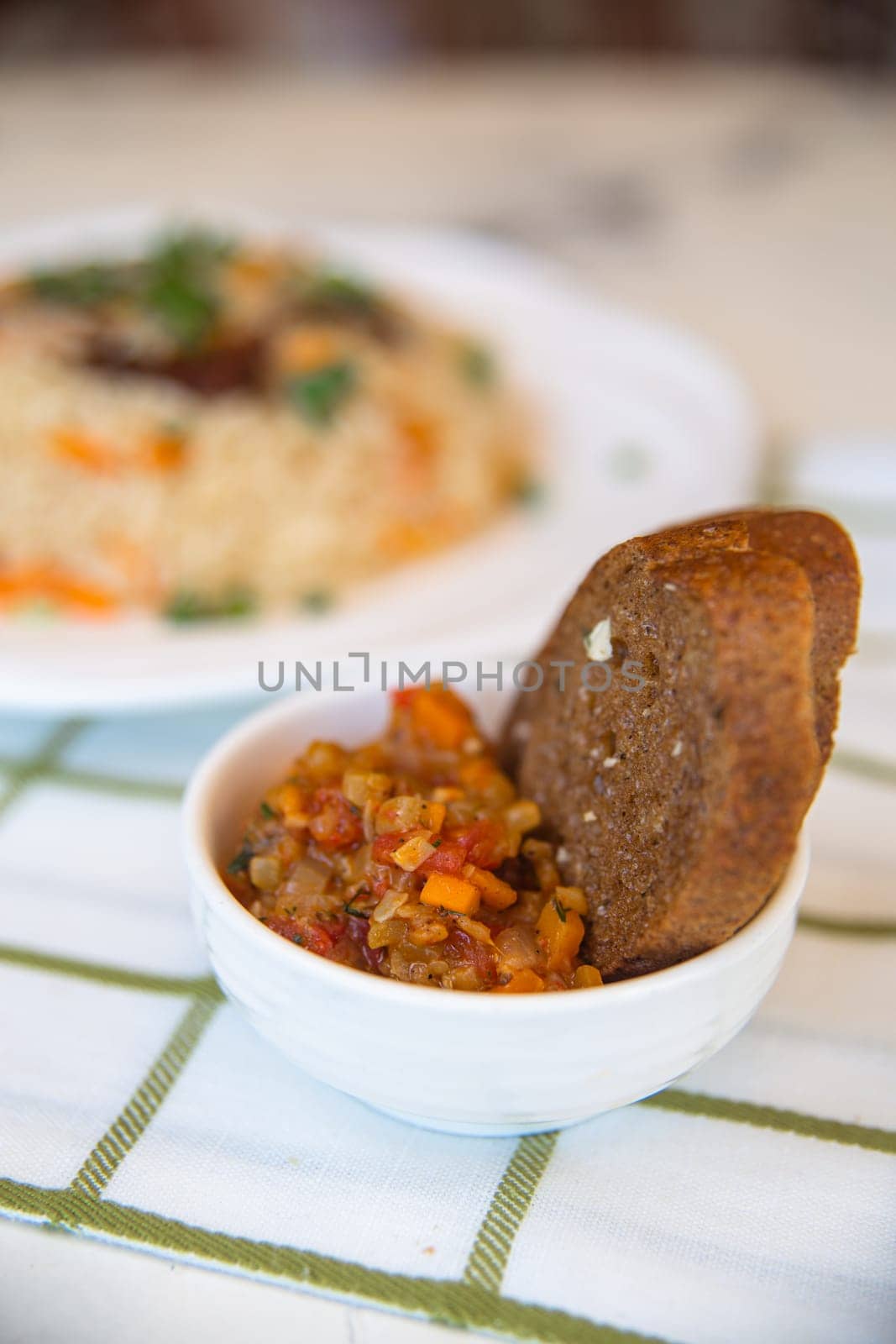 top view of a piece of bread and a spicy vegetable salad on the table.