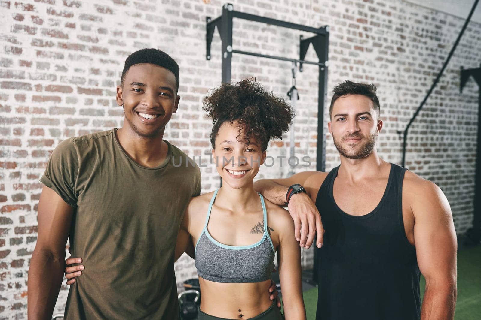 Make physical exercise a little more interesting. a fitness group standing together in the gym. by YuriArcurs