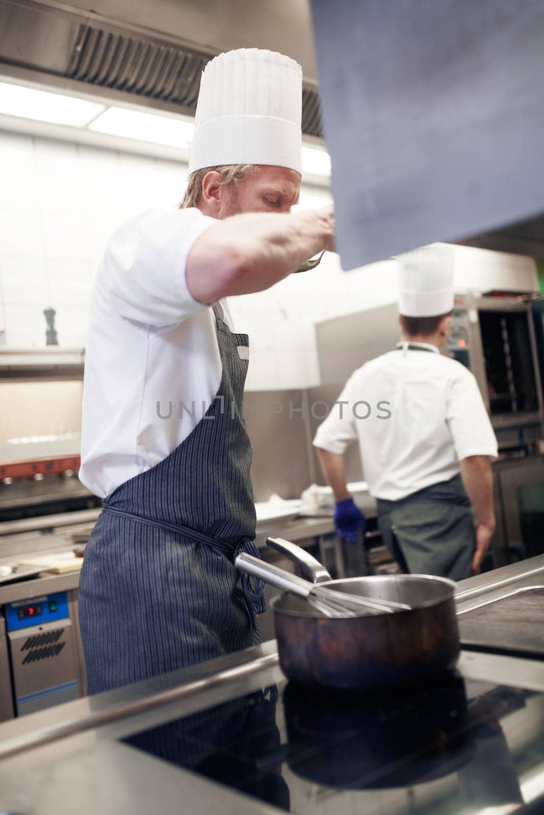 Always taste your food. chefs preparing a meal service in a professional kitchen. by YuriArcurs