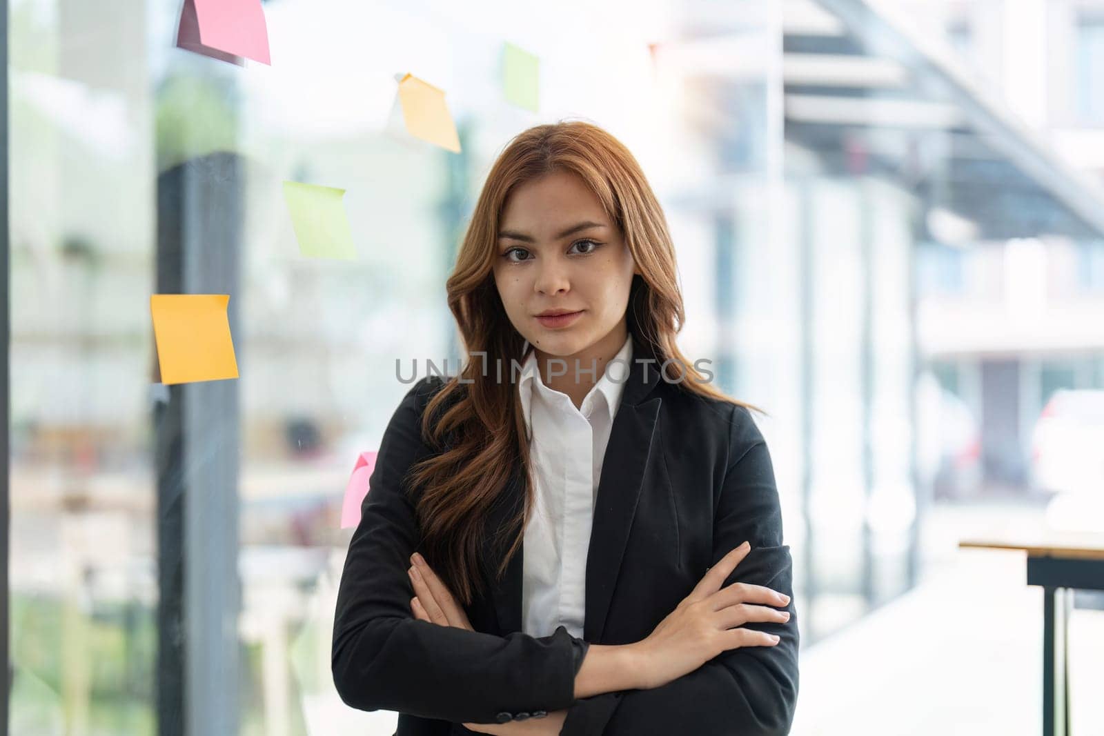 Portrait young confident Asian business woman leader, successful entrepreneur, elegant professional company executive ceo manager, wearing suit standing in office with arms crossed in meeting room.