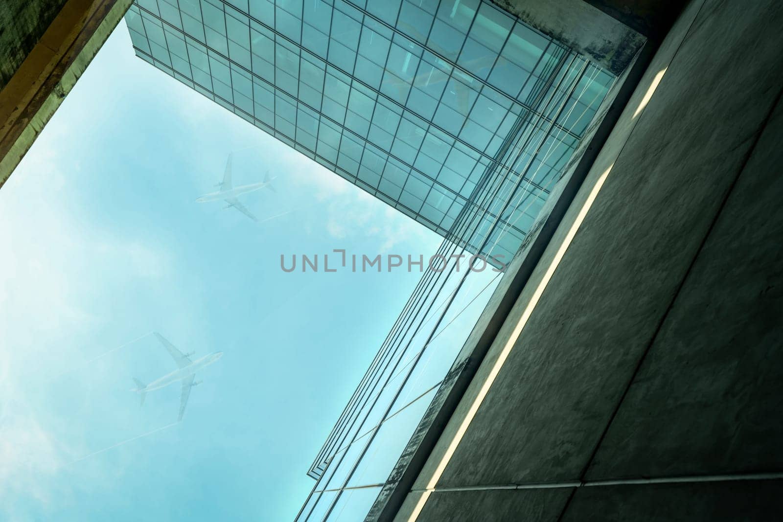 Bottom up view of modern sustainable glass office building and airplane flying in blue sky. Exterior view of corporate headquarters glass building architecture. Energy-efficient building. Glass window by Fahroni