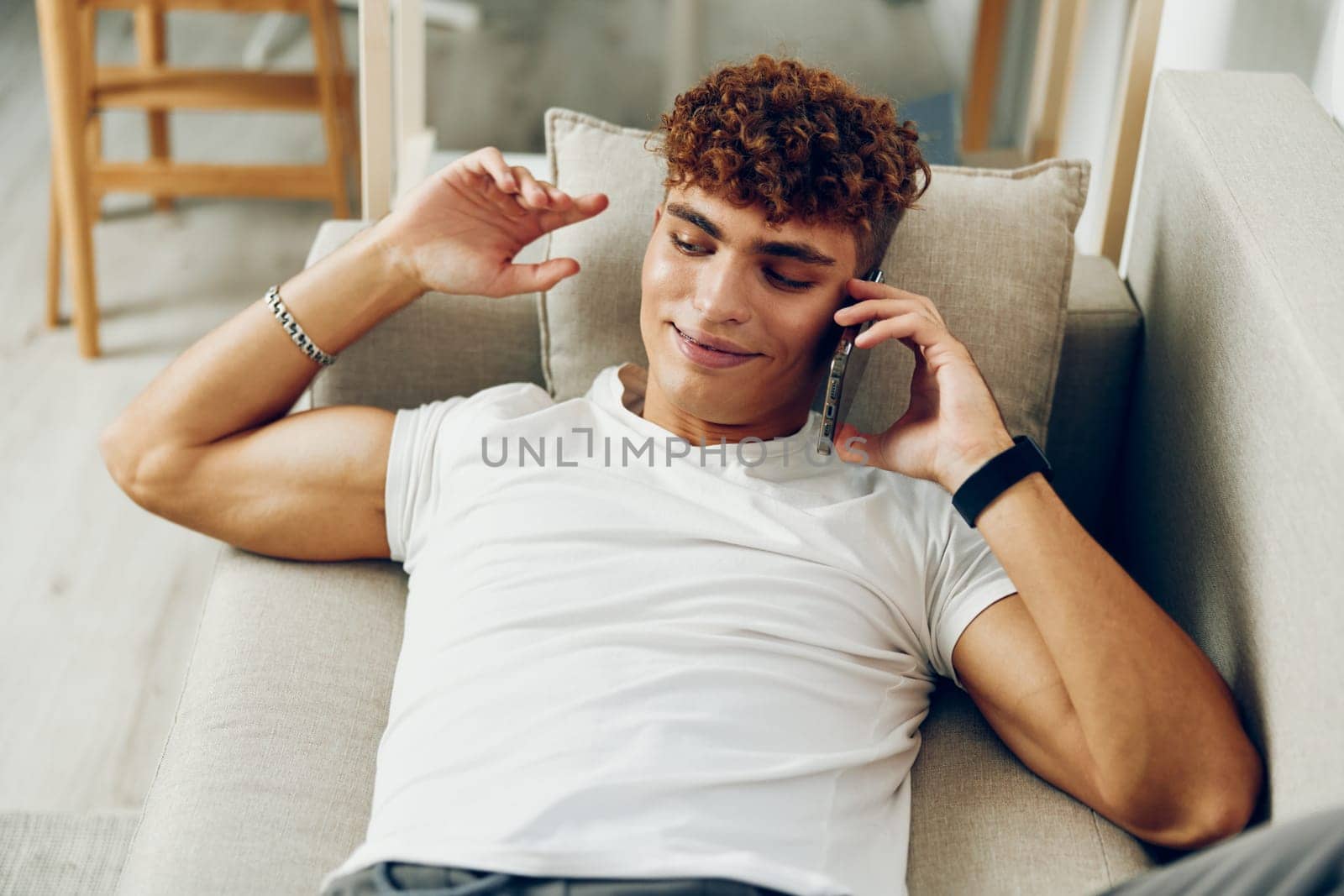 man interior curly home smile laptop communication text message talking sitting adult business cell message sports teenager blissful blogger selfies online