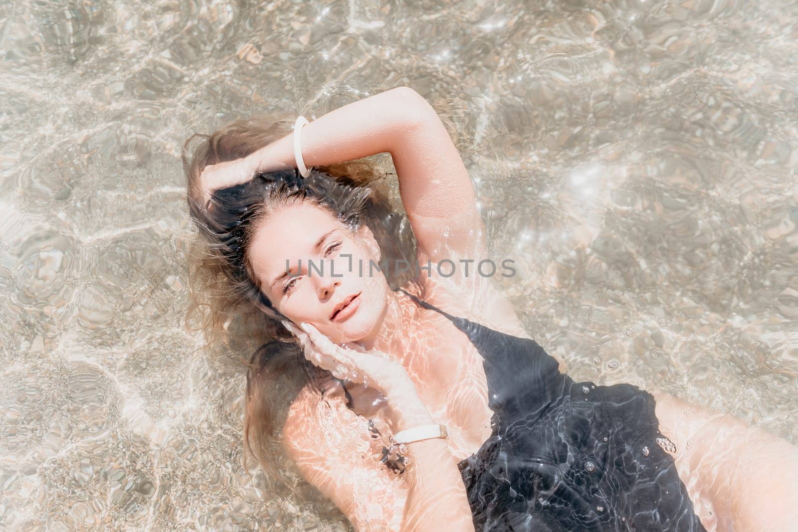 Woman travel sea. Young Happy woman in a long red dress posing on a beach near the sea on background of volcanic rocks, like in Iceland, sharing travel adventure journey