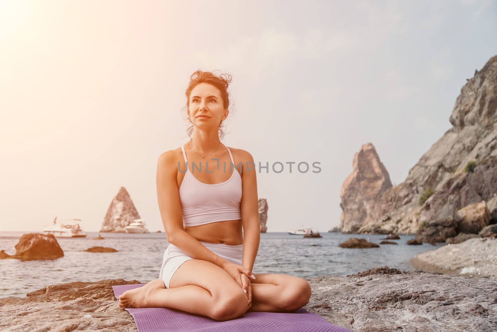 Fitness woman sea. Outdoor workout on yoga mat in park near to ocean beach. Female fitness pilates yoga routine concept. Healthy lifestyle. Happy fit woman exercising with rubber band in park.
