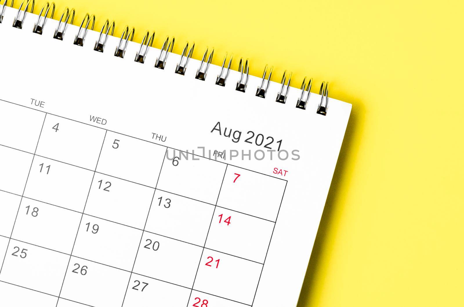 Close up August 2021 desk calendar on yellow background.