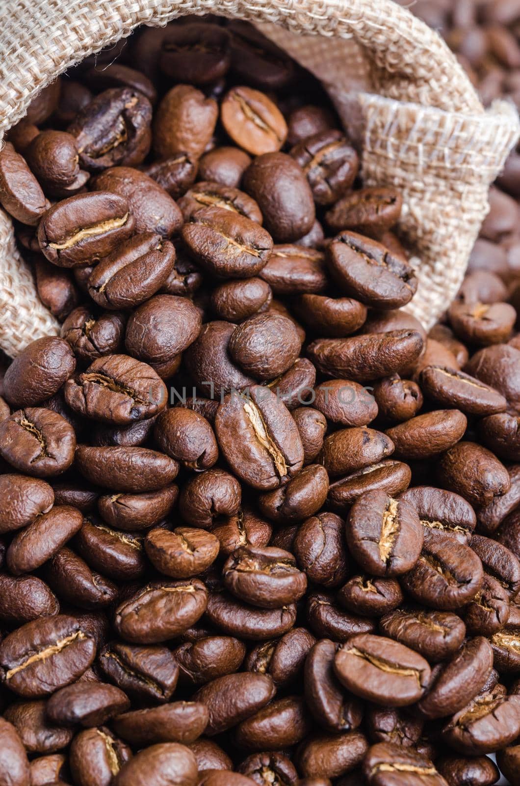 Coffee beans in sack bag. by Gamjai