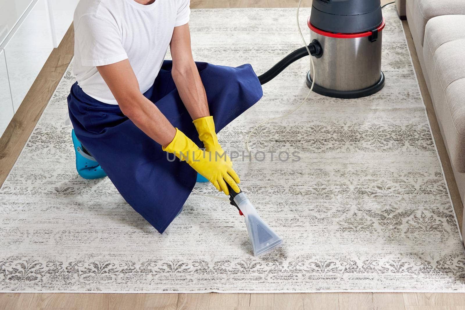 Close-up Of A Person Cleaning Carpet With Vacuum Cleaner
