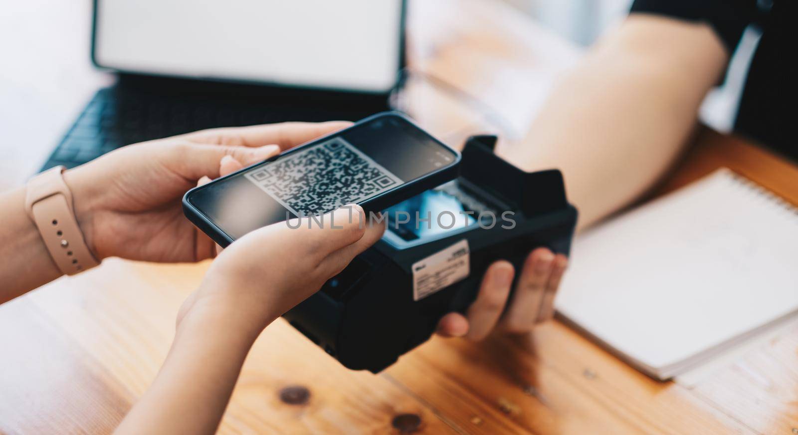 A woan using her mobile to made a payment wireless with EDC machine or credit card terminal. Mobile payment concept with virtual credit card by nateemee