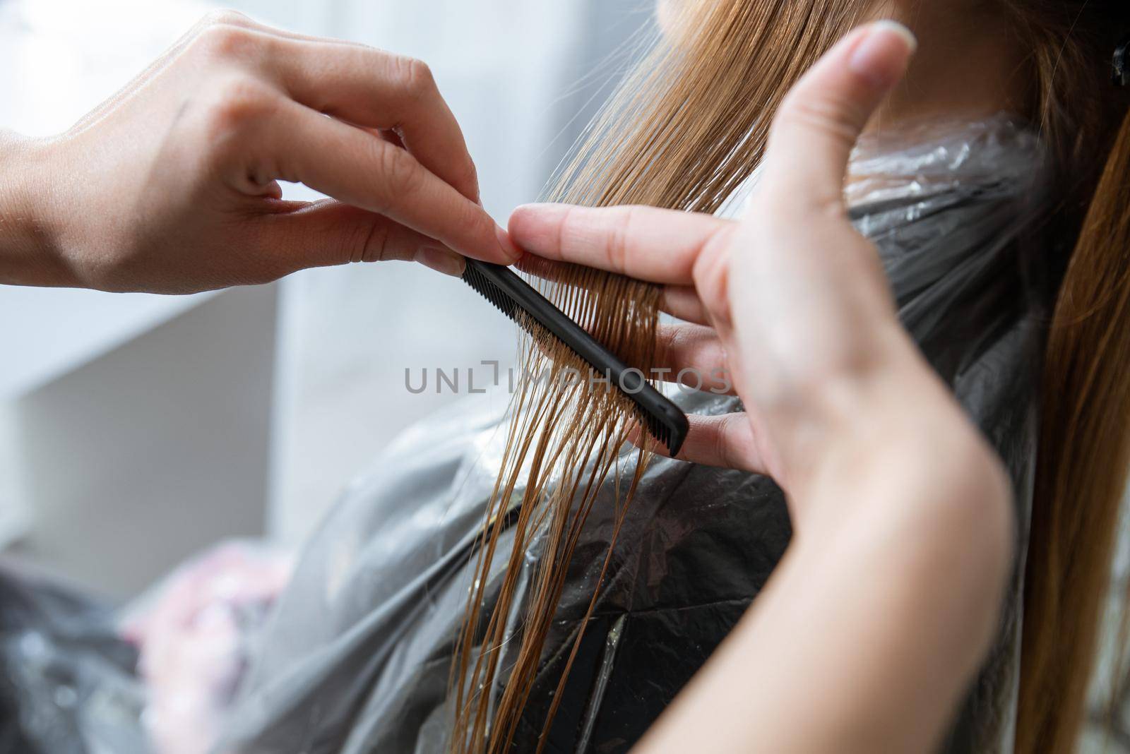 Hairdresser cut hair of a blonde girl