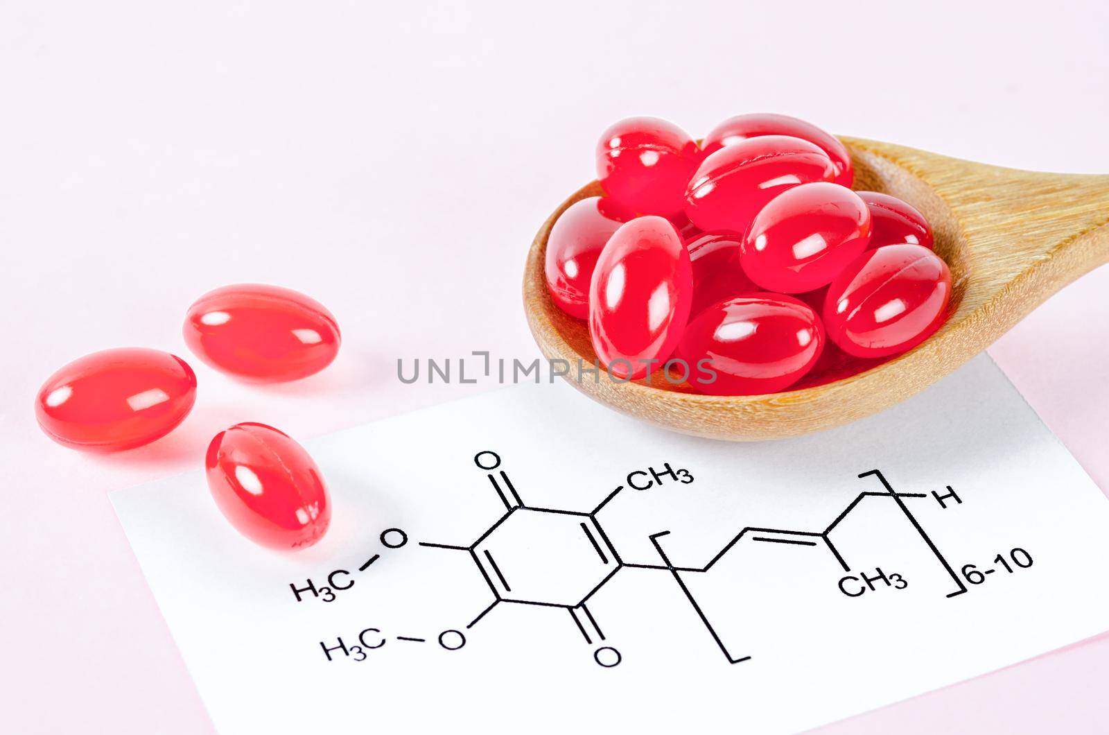 Vitamin Coenzyme Q10 with chemical formula on a pink background. To prevent aging. Pills and medicine