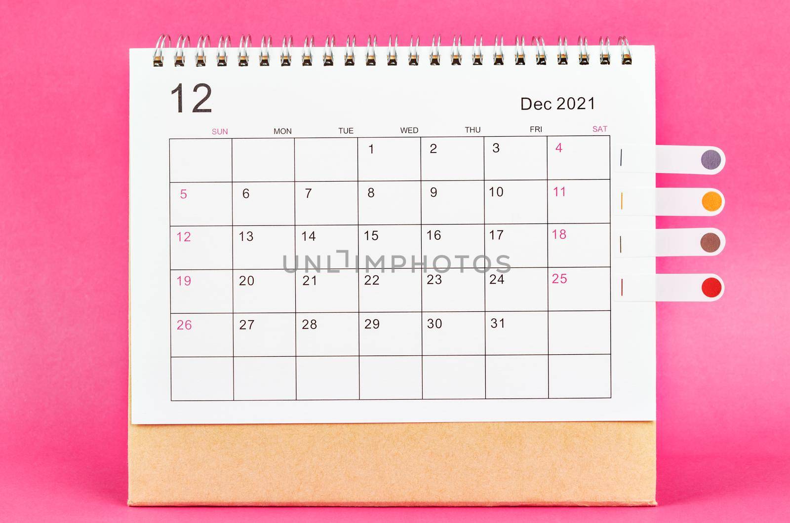 December 2021 calendar on pink background.