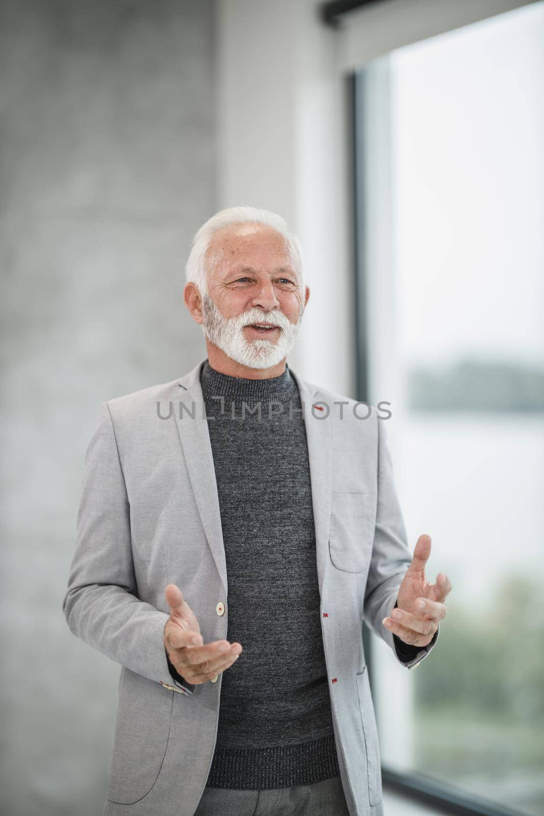 Portrait of a smiling senior businessman working in a modern office.