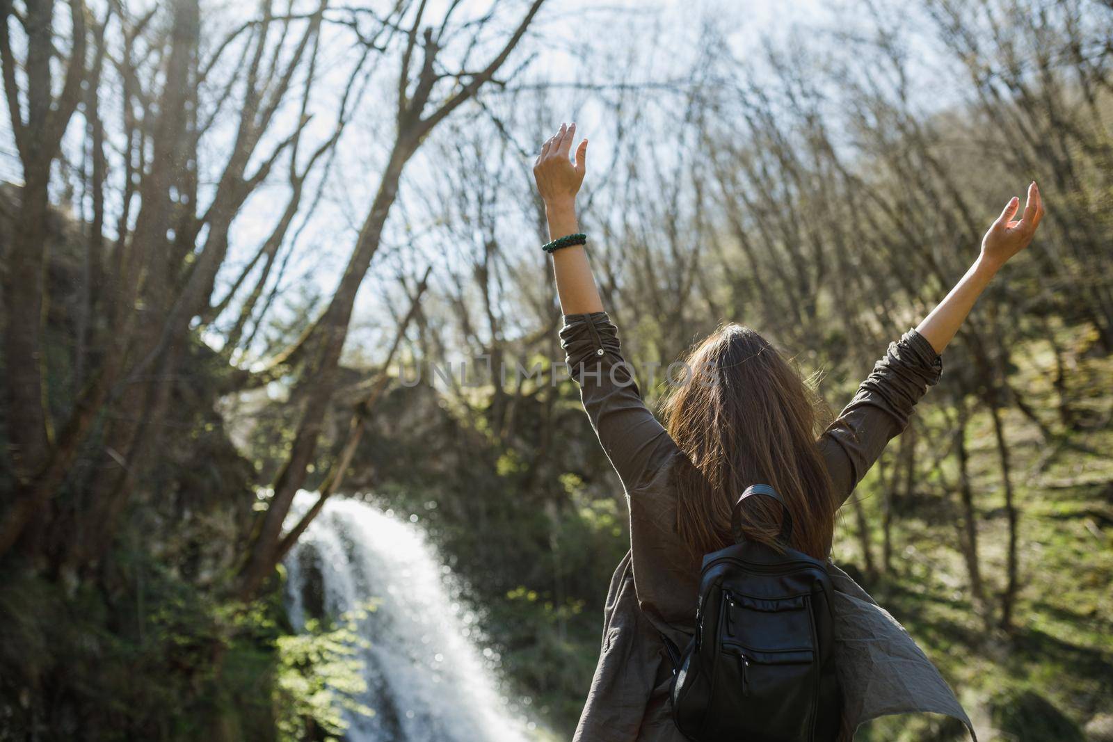 Rear view of a cheerful young woman enjoying the outdoors.