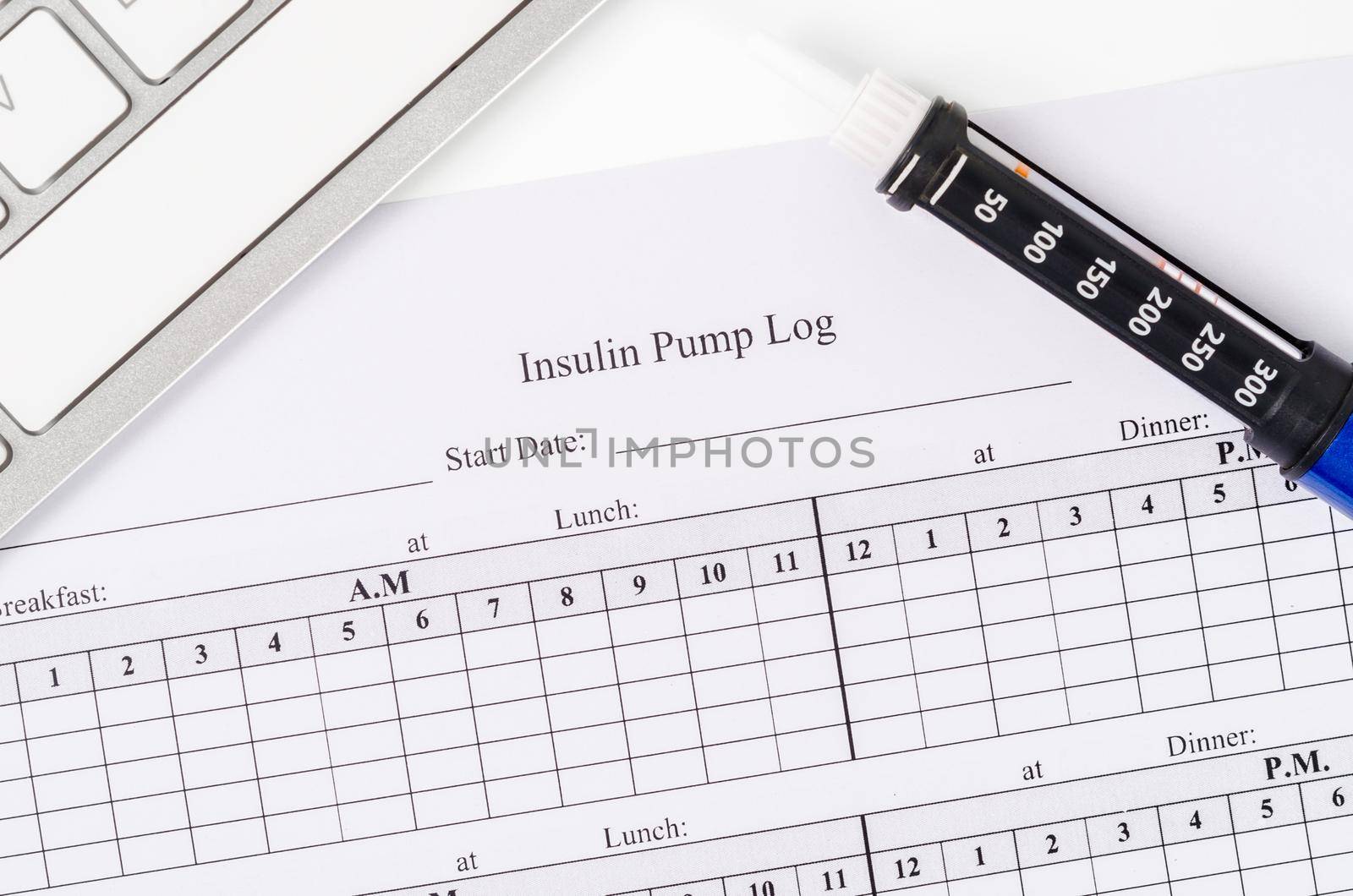 Insulin pump log record form and syringe wiht insulin for patient.