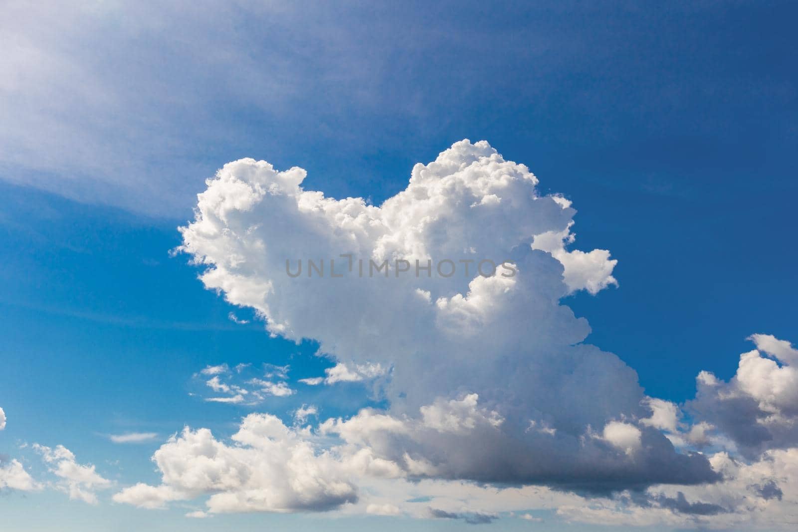 Heart shaped cloud on bright blue sky and white clouds.