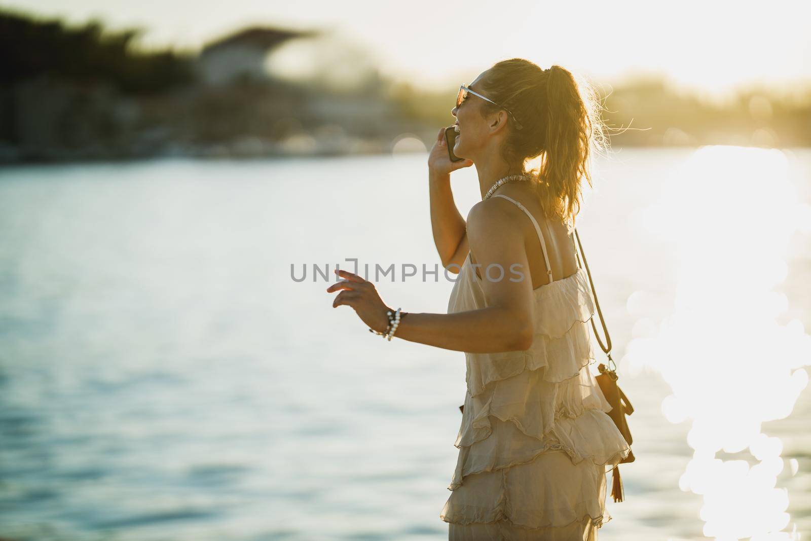 Shot of a young woman using her smartphone while exploring the wonderful seaside of Mediterranean.