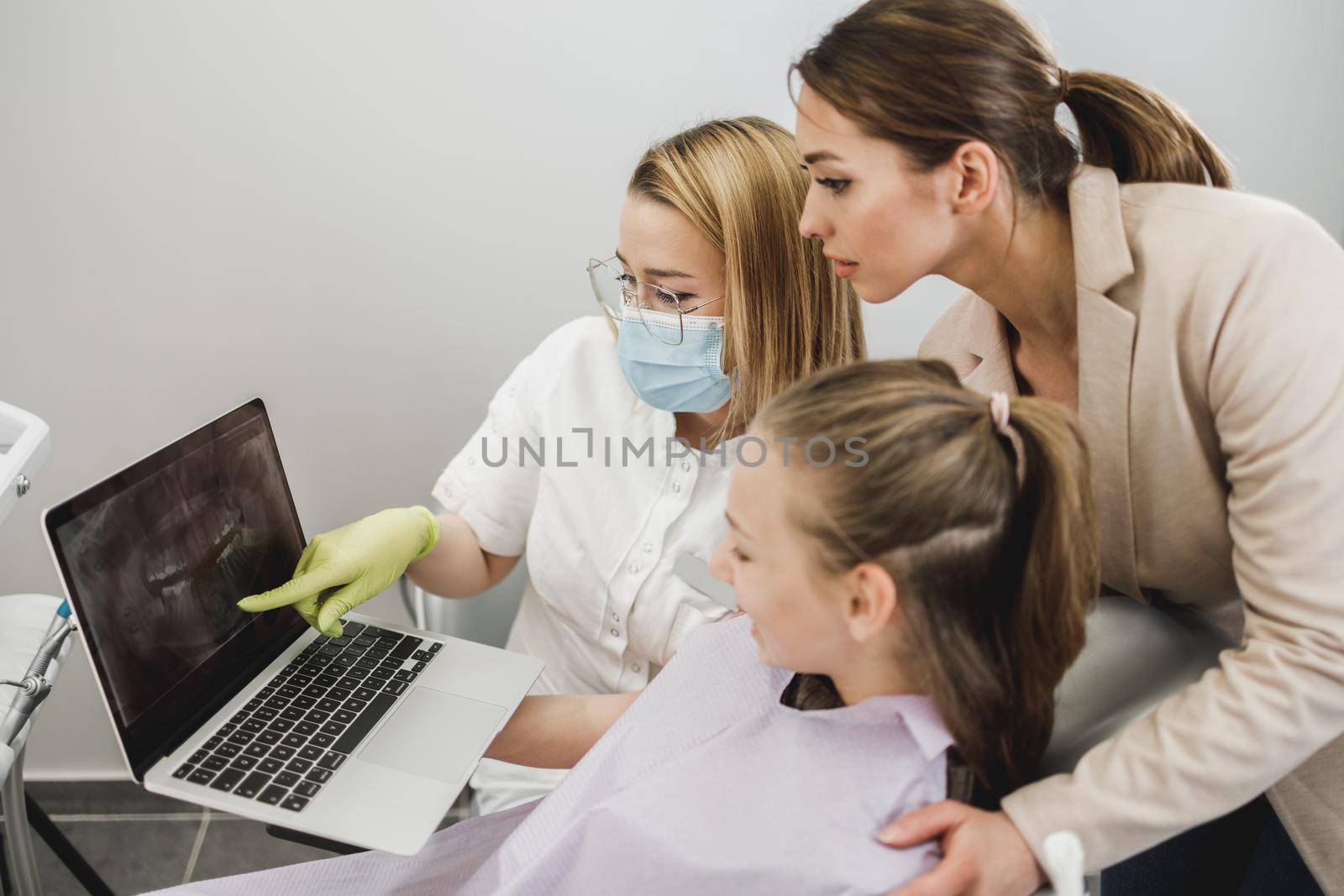 Shot of a teenager girl and her mom having a consultation with her dentist.