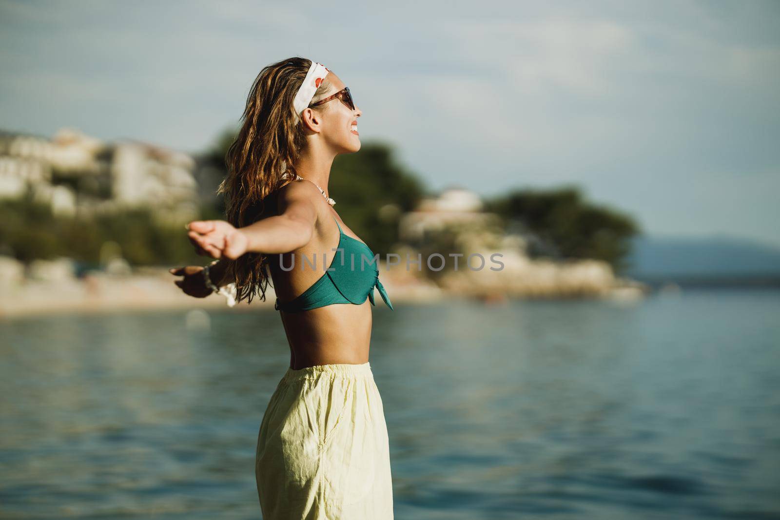 An attractive young woman in bikini is having fun on the beach and enjoying a summer vacation.