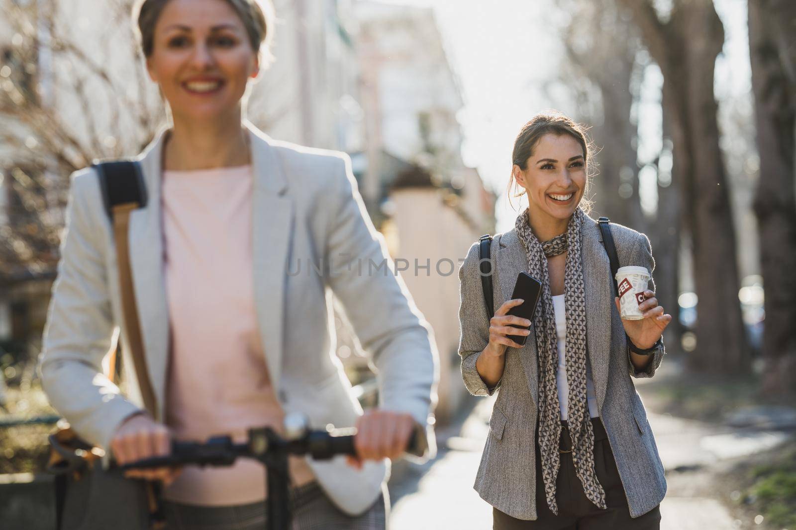 A young business women having a quick coffe break at the street.