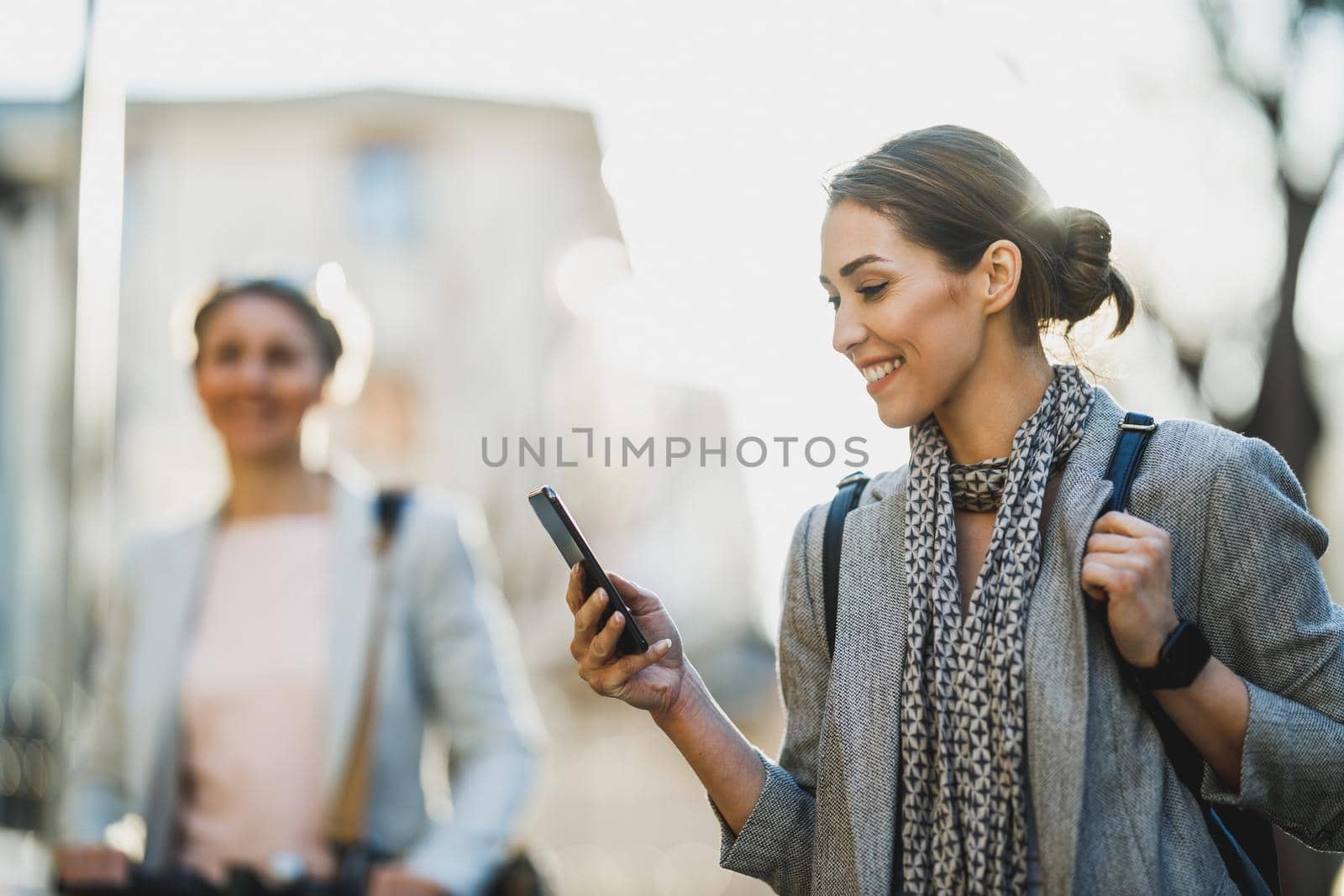 A young businesswoman reading message on a  smartphone while going to work.