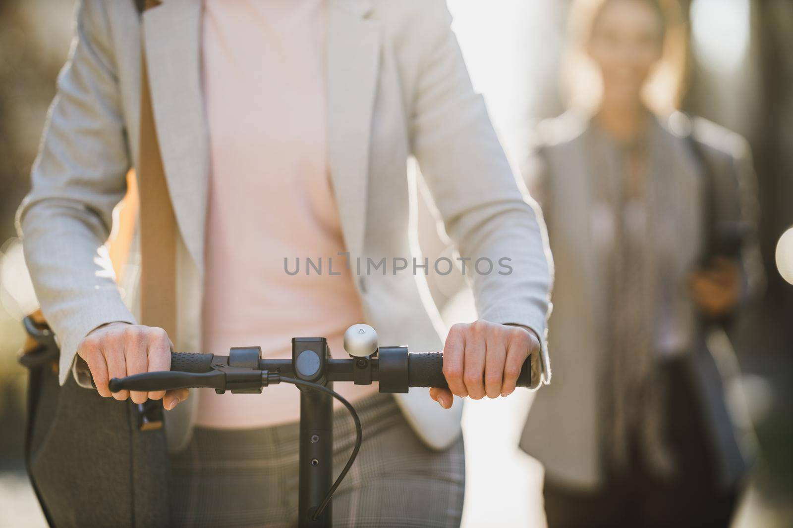 Shot of an unrecognisable businesswoman riding an electric scooter on her way to work.