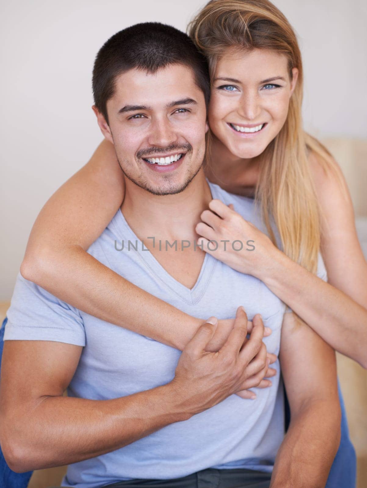 Young and in love. Attractive young couple relaxing together happily at home
