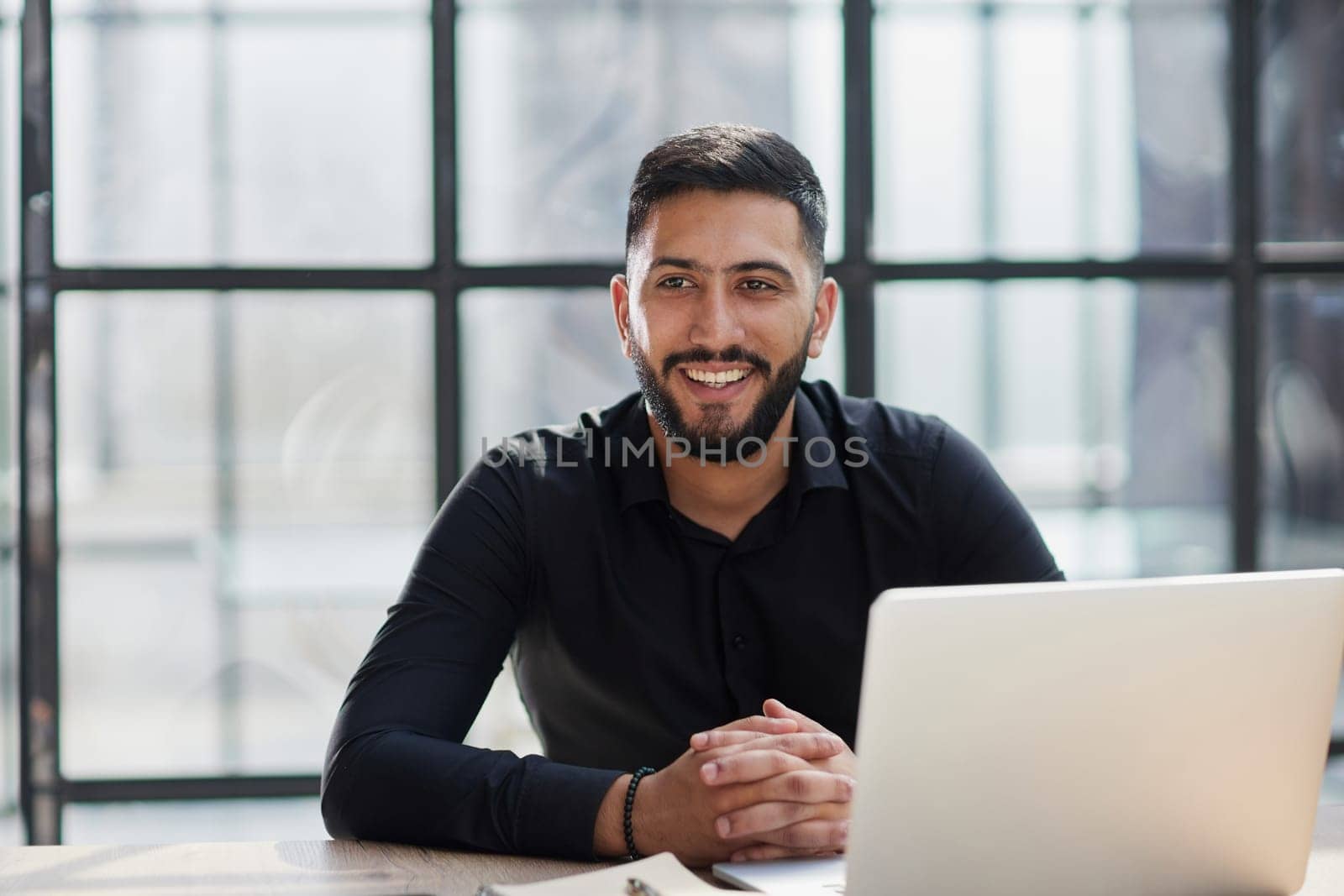 Bearded young businessman working on modern office. Consultant man thinking looking in monitor computer