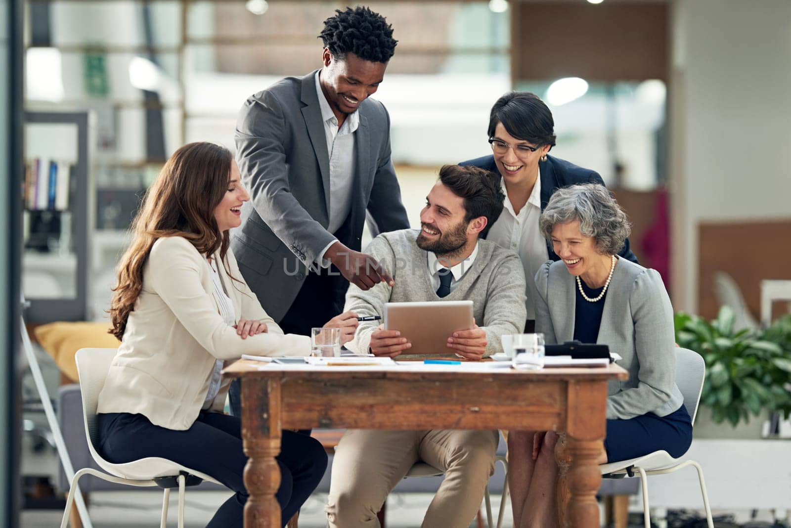 Business people, tablet or black man talking in meeting for ideas, strategy or planning a startup company. Digital, teamwork or employees in group discussion or speaking for online growth in office by YuriArcurs