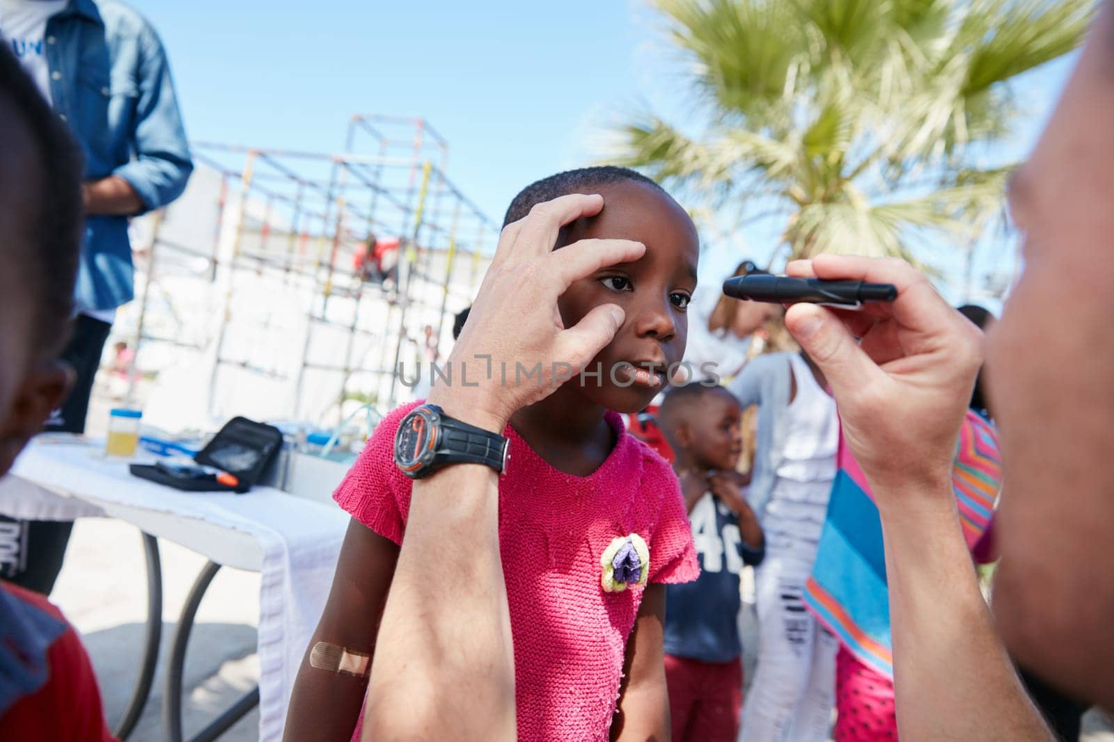 Making sure he has a clear vision of his future. a volunteer doctor giving checkups to underprivileged kids. by YuriArcurs