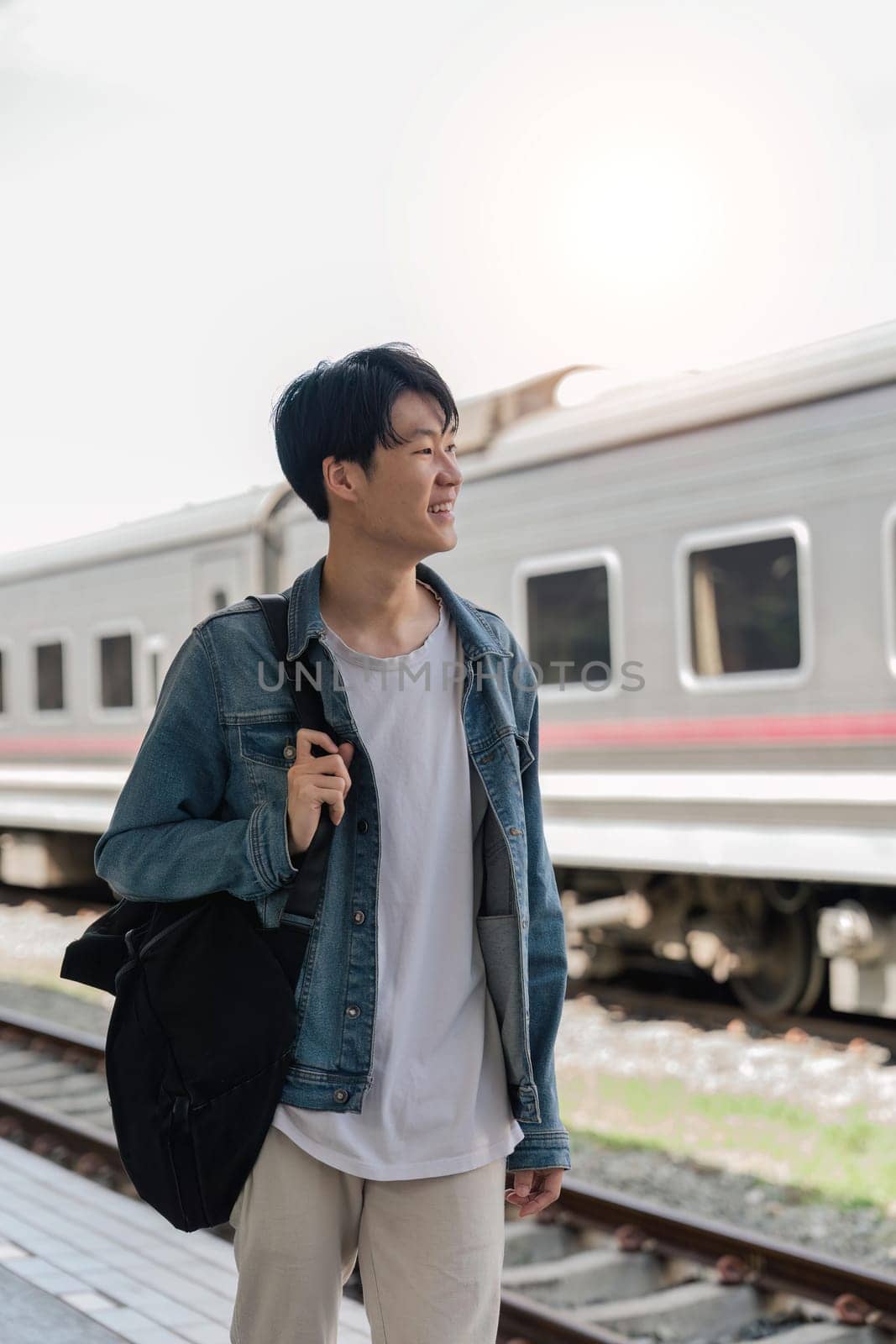 Young asian man travel by train. Freedom trip on vacation time holiday weekend by nateemee
