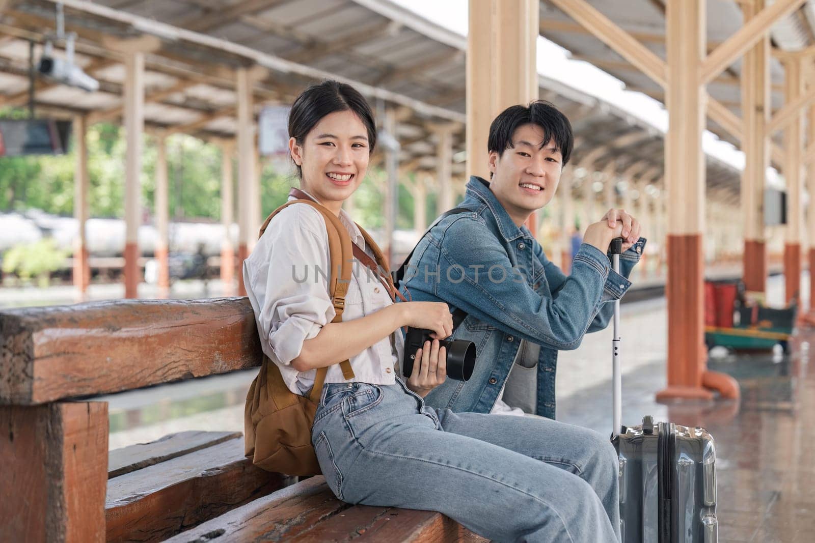 Beautiful couple at railway station waiting for the train. Young woman and man waiting to board a train.