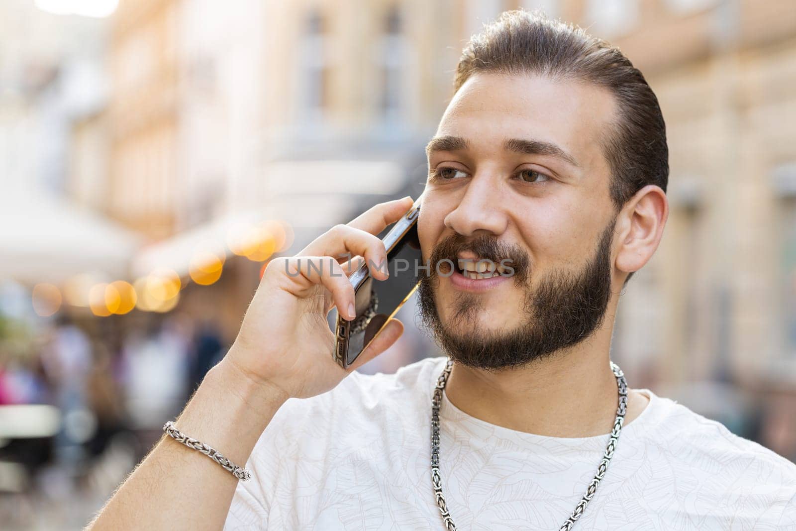 Portrait of man tourist having remote conversation communicate speaking by smartphone with friend, talking on phone unexpected good news gossip walking in urban city street. Town lifestyles outdoors
