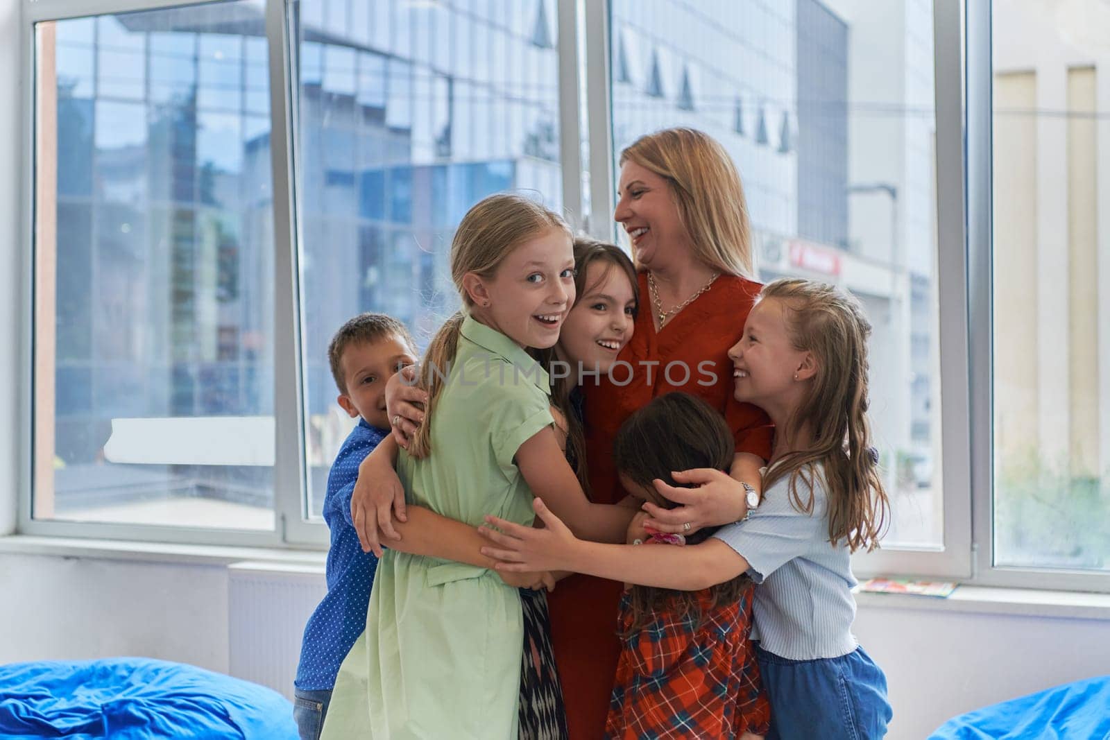 A child hugging a teacher in a modern kindergarten by dotshock