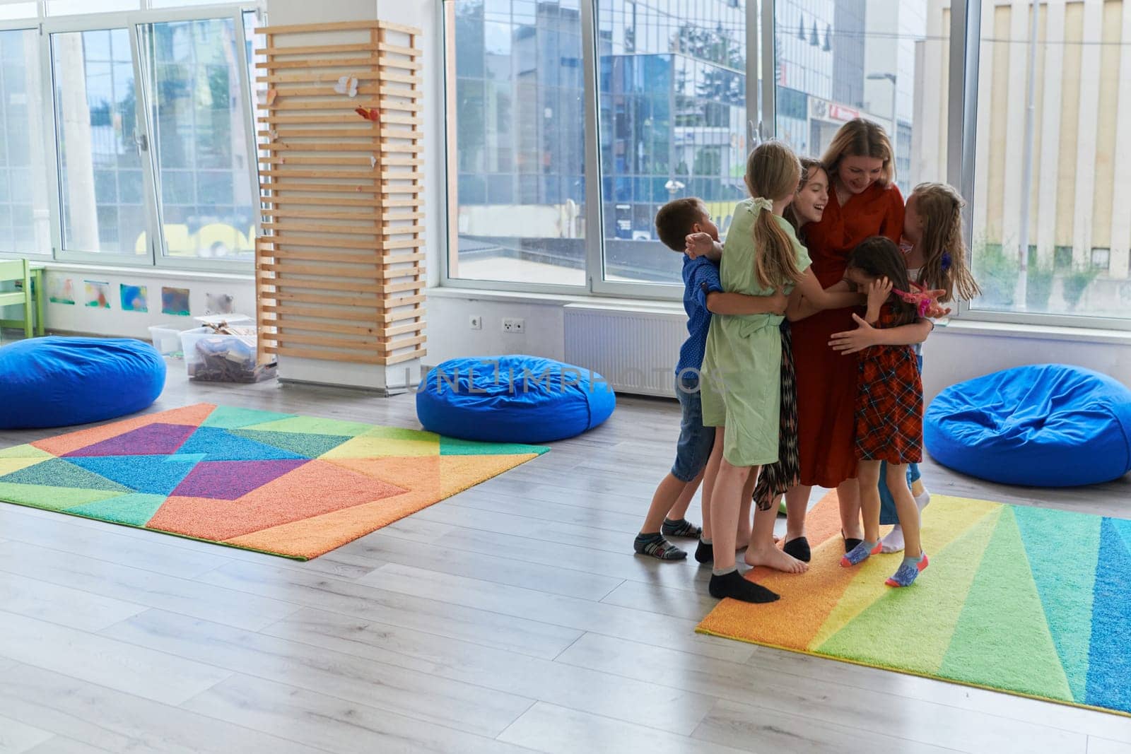 A child hugging a teacher in a modern kindergarten. High quality photo