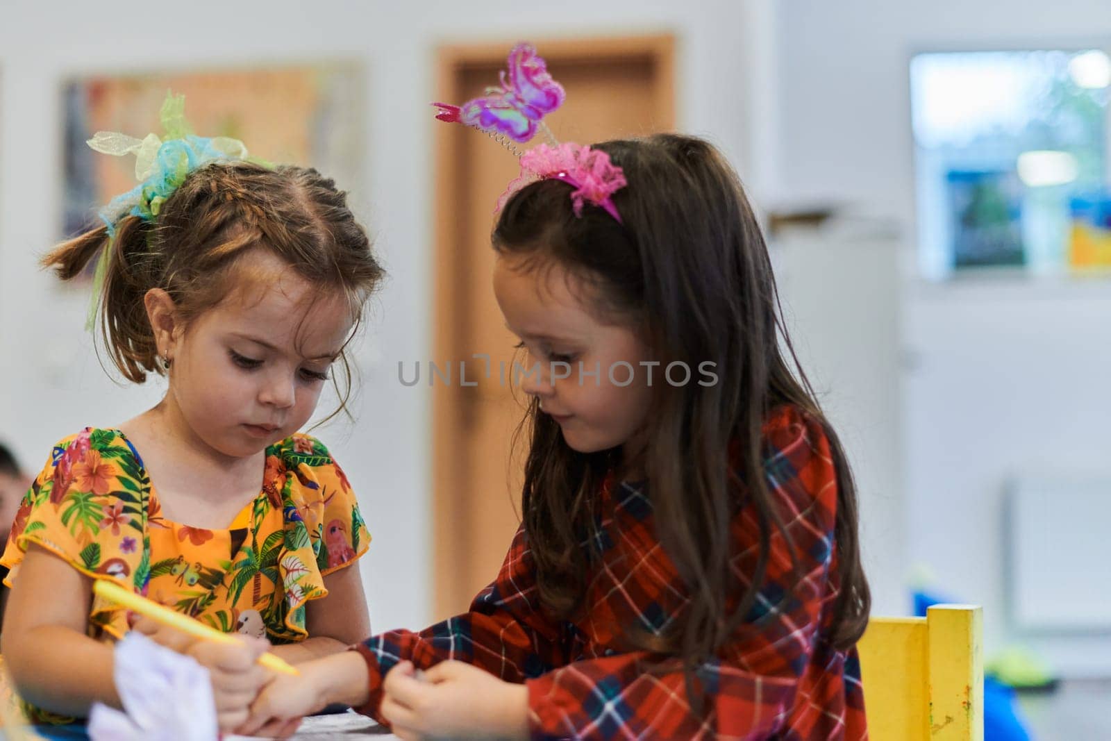 Creative kids sitting in a preschool institution, draw and have fun while they get an education. High quality photo