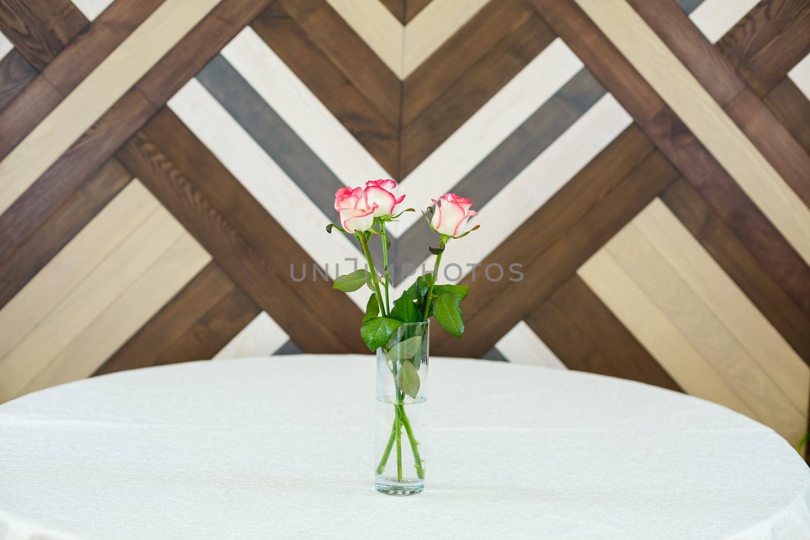 pink roses in a transparent vase on a tablecloth