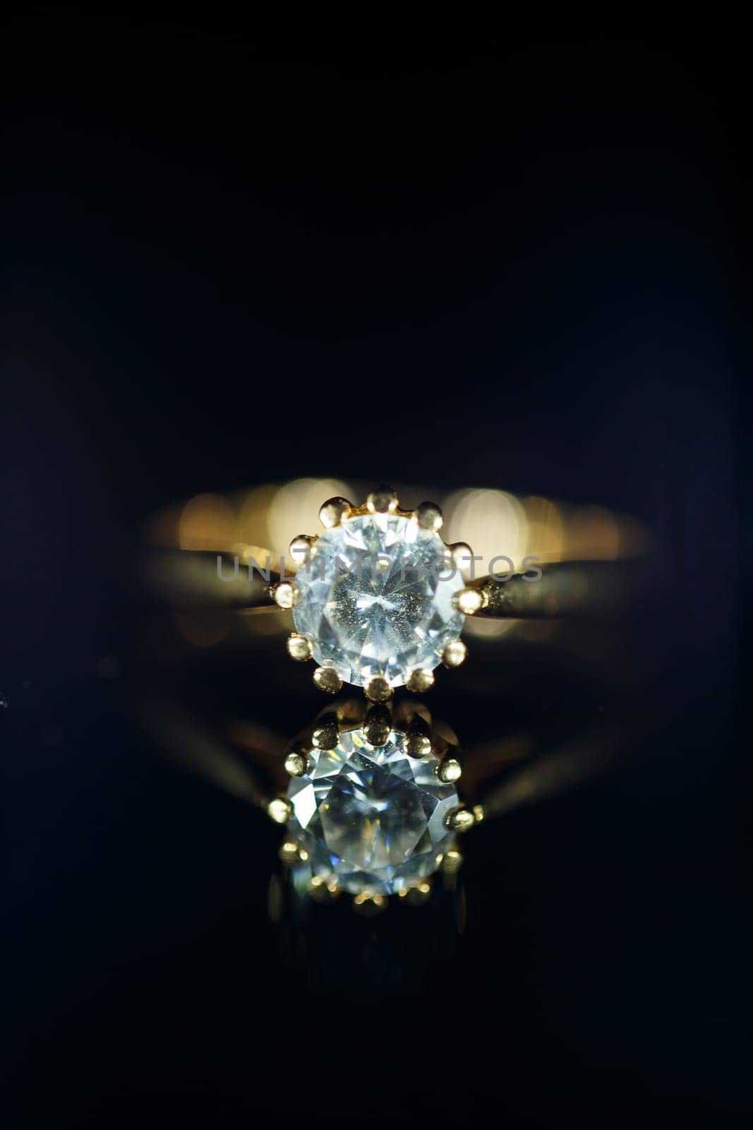 Gold wedding ring on black glass by Dmitrytph