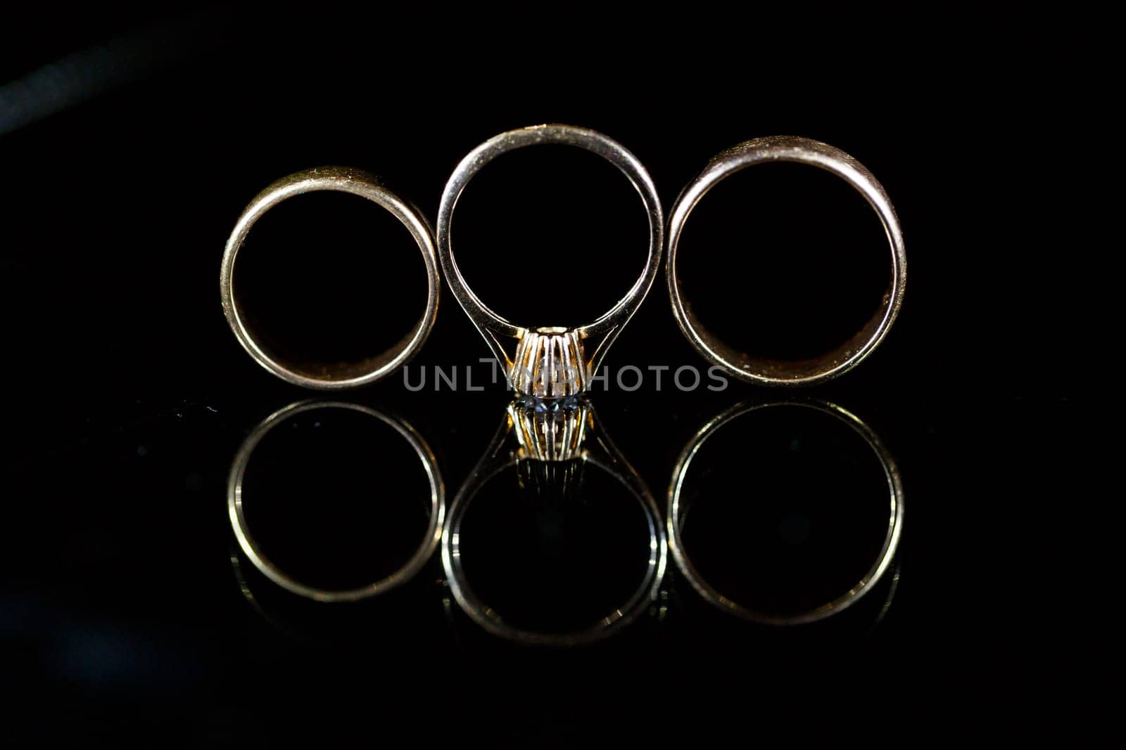 Gold wedding ring on black glass by Dmitrytph